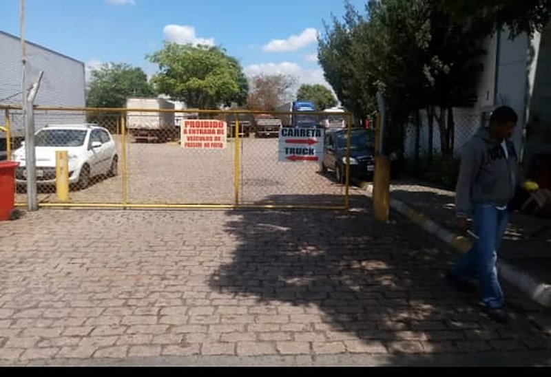 Entrada do estacionamento com portão e sinalização